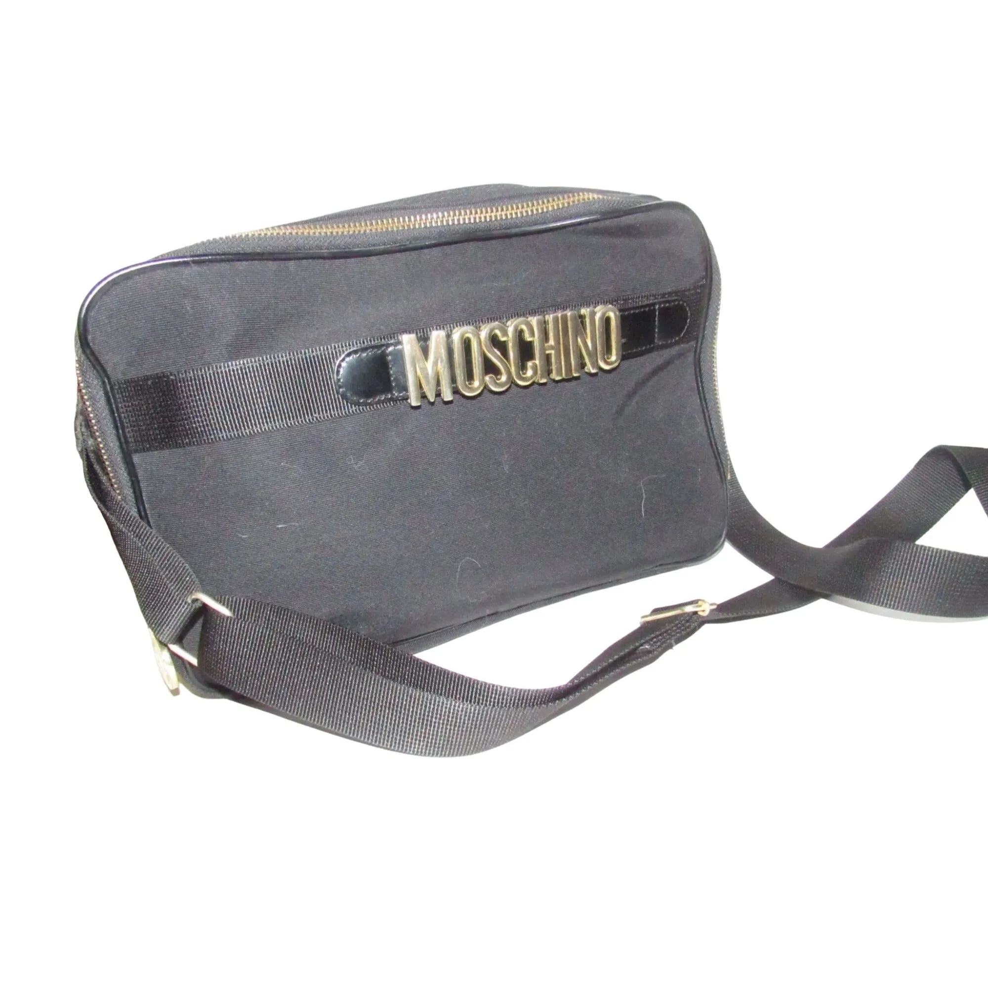 Moschino, black canvas & leather, cross body with a zip top, bold, gold, MOSCHINO letter accents, & a long strap with snaps on both sides
