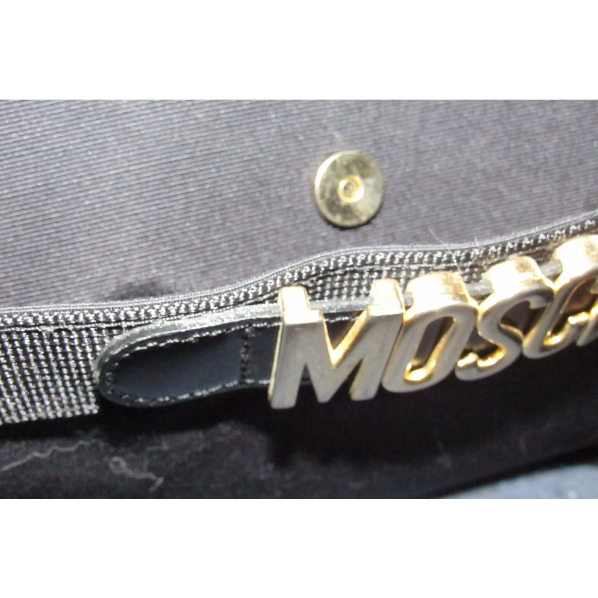 Moschino, black canvas & leather, cross body with a zip top, bold, gold, MOSCHINO letter accents, & a long strap with snaps on both sides